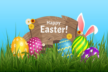 Ears of an Easter bunnyabove the grass and flowers, blue nature background with wooden board lettering Happy Easter
