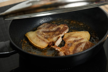 pork chop is cooked in a frying pan in sunflower oil