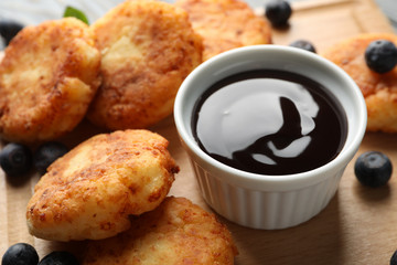 Breakfast of cheese pancakes on wooden background, close up