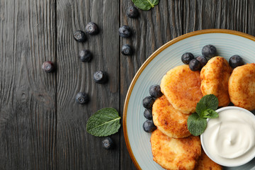 Breakfast of cheese pancakes on wooden background, top view