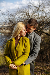Fototapeta premium guy hugs a beautiful girl in the park