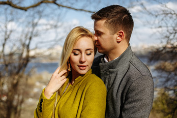 Fototapeta premium guy hugs a beautiful girl in the park