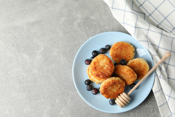 Breakfast of cheese pancakes on grey background, top view