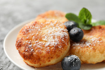 Breakfast of cheese pancakes on grey background, close up