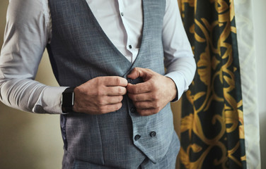 Businessman wears a jacket,male hands closeup,groom getting ready in the morning before wedding...