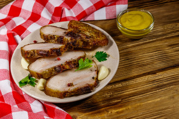 Baked pork belly in a plate on wooden table