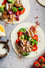 Falafel with tortilla, vegetables and tahini dressing, top view.