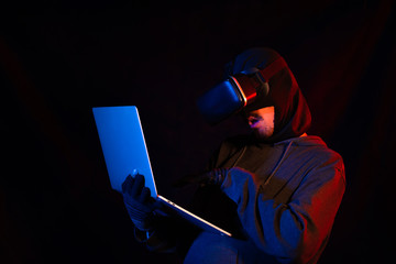 Masked robbers on a black background are using modern technology tools.