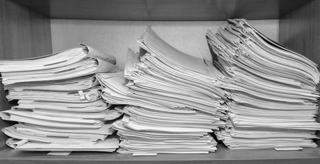 Paper documents stacked in archive. Documents on the shelves of archive room. Office shelves in the...