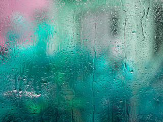 Wet glass with colorful blurs