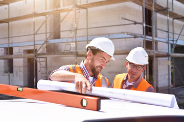 construction manager and architect on site during the construction of a house - planning and control on site - teamwork