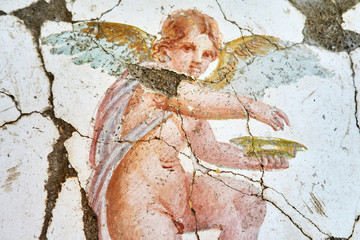 Fresco winged cupid in a Domus of the ancient Pompeii, the ancient Roman city of Pompeii destroyed by the eruption of Volcano Vesuvius in 79 BC
