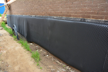 Exterior waterproofing of building foundation with a waterproofing membrane and soil side drainage...