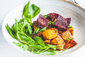 Baked beetroot and sweet potato with spinach salad. Vegan food concept.