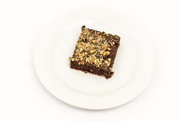 Chocolate Cake With Grated Nuts On The Plate Isolated Above White Background