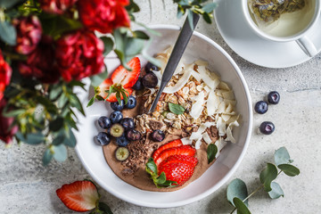 Healthy breakfast bowl with granola, berries and coconut, top view.