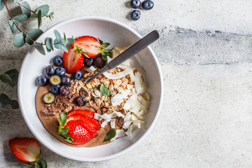 Healthy breakfast bowl with granola, berries and coconut, top view.