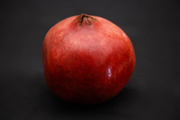 Fototapeta na wymiar Closeup red pomegranate Isolated on a black background.