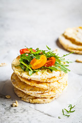 Corn crispbread with arugula and tomatoes.