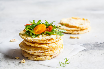 Corn crispbread with arugula and tomatoes.
