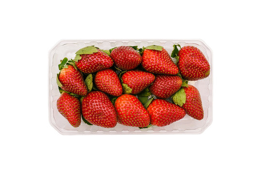 Plastic container with strawberries isolated on a white background. Fresh and ripe summer berries in the package. Top view, flat lay.