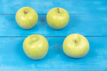 Green Raw Apples On The Blue Wooden Board Table