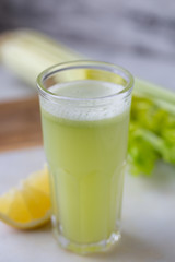 Celery juice in a  glass.  view over a rustic marble white  background.