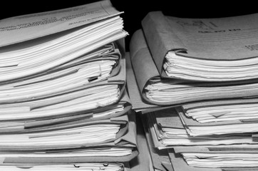 Paper documents stacked in archive. Documents on the shelves of archive room. Office shelves in the closet full of files. black and white photo