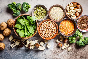 Vegan sources of protein background. Tofu, chickpeas, lentils, nuts, spinach and broccoli - vegetable proteins.