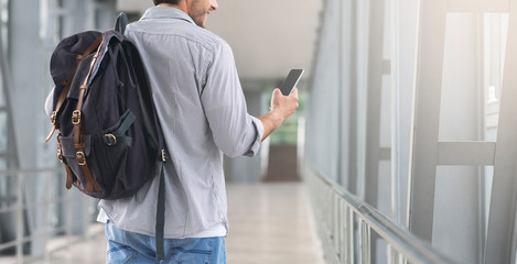 Unrecognizable Man Walking In Airport Terminal And Using Smartphone, Browsing Internet