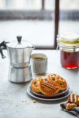 Homemade jam cookies with coffee on kitchen table.