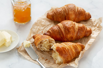freshly baked croissants with jam and butter for breakfast