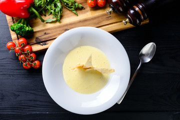 Cheese soup with toasts in blue pottery