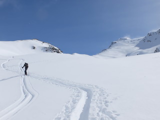 Fototapeta na wymiar Skieurs de ski de randonnée et alpiniste en montagne qui skient sur la neige et la glace en plein soleil des alpes dans le Queyras de saint Véran