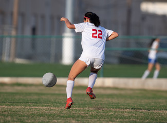 High school girl competing in a soccer match in south Texas
