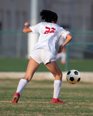 High school girl competing in a soccer match in south Texas