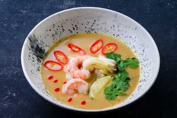 thai traditional tom yam kung soup in a white bowl