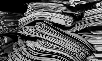 Paper documents stacked in archive. Documents on the shelves of archive room. Office shelves in the closet full of files. black and white photo