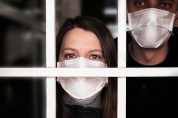 A woman in a mask , looking intently at the camera. Quarantine and isolation of patients with covid...