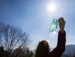 Girl freeing herself from the protective mask after overcoming illness, virus, covid-19. coronavirus