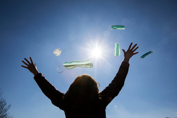 Girl freeing herself from the protective mask after overcoming illness, virus, covid-19. coronavirus