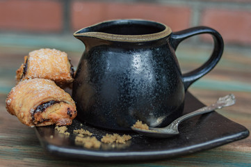 teapot and cup of tea on wooden background with delicious pastry 