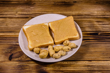 Sandwiches with peanut butter in plate on a wooden table