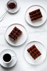 Tiramisu with coffee on white marble background