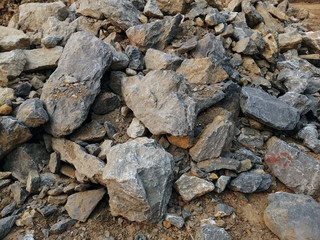 A pile of limestone rock on the ground. Limestone is a sedimentary rock composed primarily of calcium carbonate in the form of the mineral calcite.