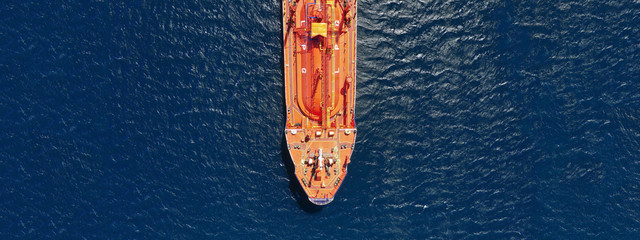 Aerial drone ultra wide top down photo of industrial LPG gas tanker ship cruising in low speed near...