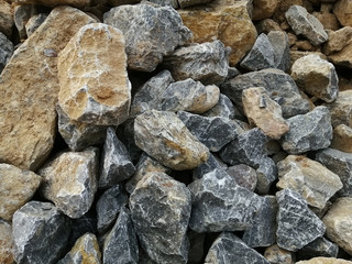 A pile of limestone rock on the ground. Limestone is a sedimentary rock composed primarily of calcium carbonate in the form of the mineral calcite.