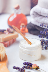 Concept of natural organic spa products. Home body and face treatment. Cream, handmade herbal soap, organic oil in glass bottle, lavender, brush, towels. Atmosphere of relax, serenity and pleasure. 