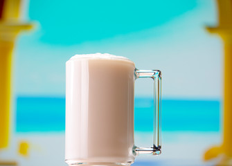 Glass mug with handle filled with coconut milk
