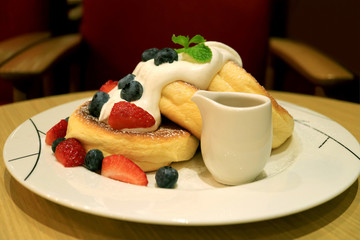 Plate of Fluffy Souffle Pancakes Topped with Fresh Mix Berries and Mascarpone Cream